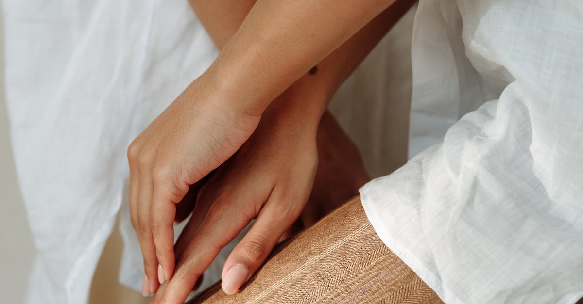 Elegant close-up of hands resting gently on a textured fabric, conveying warmth and style.